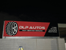 a red and black sign for dlp autos shows a tire on it