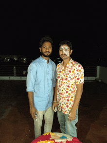 two men standing next to each other with their faces covered in white frosting