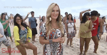 a woman stands in front of a group of people on a beach with the word sabrina on the bottom