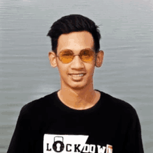 a man wearing sunglasses and a black shirt that says lock down