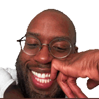 a man with glasses and a beard is smiling and touching his nose