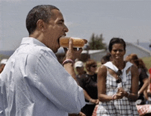 a man is eating a hot dog with his mouth open