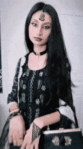 a woman with long black hair is wearing a choker and holding a black bag