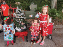 a girl wearing a red shirt that says ' united way ' on it stands next to two other girls