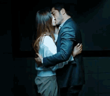 a man and woman kissing in a dark room