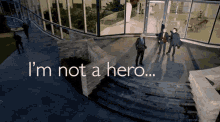 a group of men standing in front of a building with the words " i 'm not a hero " on the bottom