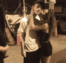 a woman kisses a boy on the cheek in front of a sign that says parking