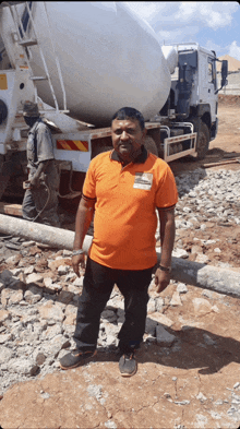 a man in an orange shirt is standing in front of a white truck