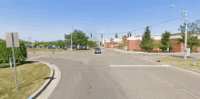 a car is driving down a street next to a brick building .