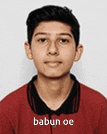 a young man wearing a red shirt with babun oe on it