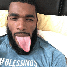 a man sticking his tongue out and wearing a shirt that says blessings