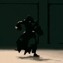 a silhouette of a person dancing in a dark room with kapwing written on the bottom