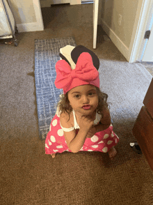 a little girl is wearing a minnie mouse costume and making a funny face