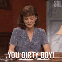 a woman sitting at a desk with the words " you dirty boy " written on her face