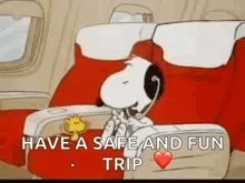 snoopy is sitting on an airplane talking on a telephone .