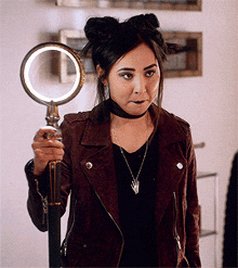 a woman is holding a magnifying glass in her hand