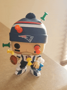 a funko pop of a patriots player with pins sticking out of his face