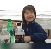 a boy holding a bottle of coca cola zero