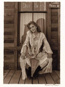 a woman is sitting on a porch in front of a sign that says dry bean