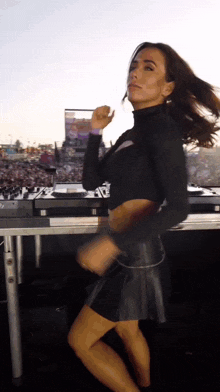 a woman in a leather skirt is dancing in front of a pioneer dj controller