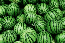 a pile of watermelons are sitting on top of each other .