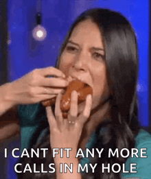 a woman is eating a donut and says i cant fit any more calls in my hole .