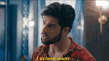 a man with a beard is wearing a plaid shirt and says i 'm born smart