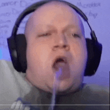 a man wearing headphones is spitting something out of his mouth