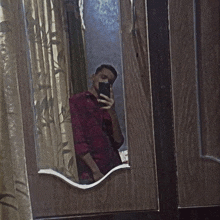 a man taking a selfie in a mirror with his phone