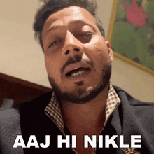 a man with a beard is saying aaj hi nikle in front of a picture