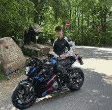 a man is sitting on a motorcycle in front of a sign that says ' a few steps to the right '