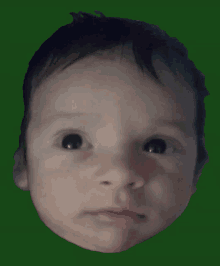 a close up of a baby 's face with a green background behind it