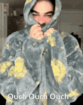 a person wearing a hoodie with the words ouch ouch ouch written on it