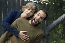 a man and a woman are posing for a picture and the woman is holding the man 's belly