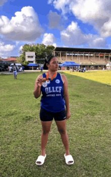 a woman wearing a blue shirt that says ollcf on it