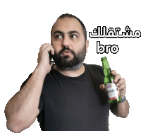 a man with a beard is talking on a cell phone while holding a bottle of beer that says bro