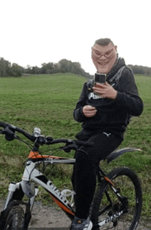 a man is sitting on a giant bike looking at his phone