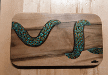 a painting of a snake on a wooden surface