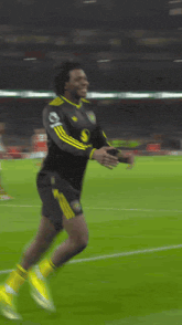 a soccer player is kneeling down on the field with a banner behind him that says ' heineken '