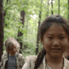 a girl in a braided ponytail is smiling in a forest with the words la guarimba film festival on the bottom