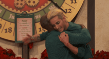 two people hugging in front of a sign that says sally on it