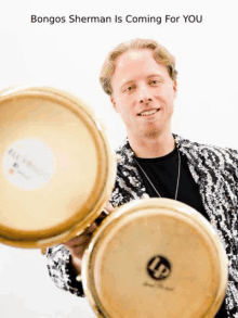 a man in a sequined jacket is holding a pair of bongos