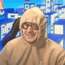 a man wearing a hoodie and goggles is smiling for the camera