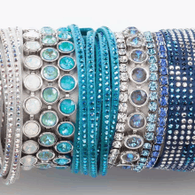 a stack of blue bracelets with rhinestones on them