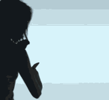 a silhouette of a woman with long hair standing in front of a white background