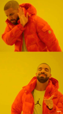 a man with a beard wearing an orange jacket is making a peace sign