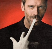 a man wearing a black shirt and a white glove is sticking his tongue out ..