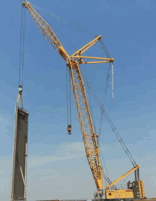 a large yellow liebherr crane is lifting something