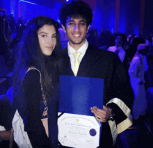 a man in a cap and gown is holding a diploma