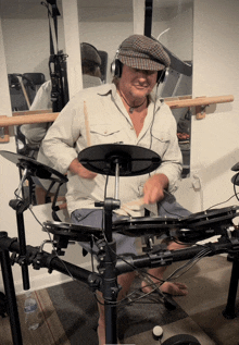 a man wearing a hat and headphones playing a drum set